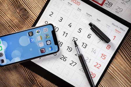KATOWICE, POLAND - February 23, 2020 : smartphone iPhone XS from Apple and calendar on 2020 year.