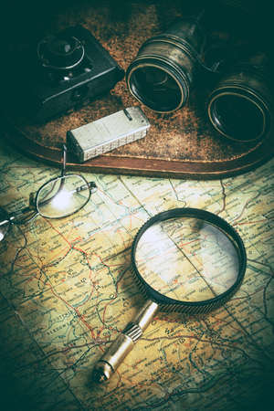 Magnifying glass and binoculars on the old map. Vintage style. Selective focus.の写真素材