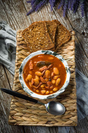 Beans with tomato sauce, bacon and sausage. Selective focus.の写真素材