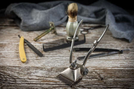 Vintage manual hair clipper on wooden background. Selective focus.の写真素材
