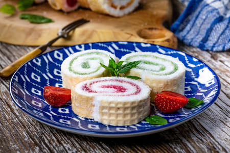 Slices of homemade sweet roll with fruit jam  on wooden background.の写真素材
