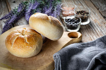 Homemade kaiser buns on wooden cutting board.の写真素材