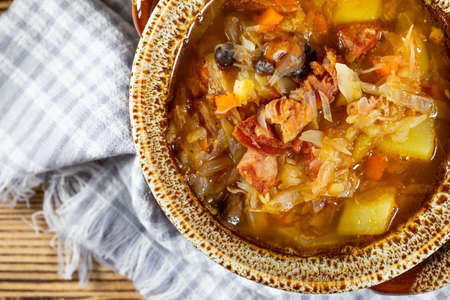 Traditional russian sour cabbage soup on wooden table. Selective focus.