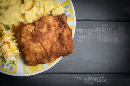 Fried cod fillet served with boiled potatoes and vegetable salad.の写真素材
