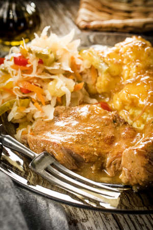 Braised pork in own sauce served with boiled potatoes and salad. Shallow depth of field.の写真素材