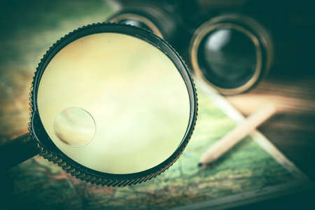 Magnifying glass and binoculars on the old map. Vintage style. Selective focus.の写真素材