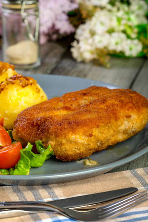 Cutlet cordon with pork ham served with boiled potato and salad on a plate.の写真素材