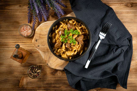 Tagliatelle mosse with beef sauce on wooden table. Dark light.の写真素材