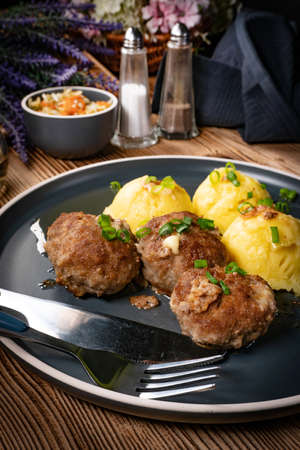 Meatballs with cheese served with boiled potatoes on a plate.の写真素材