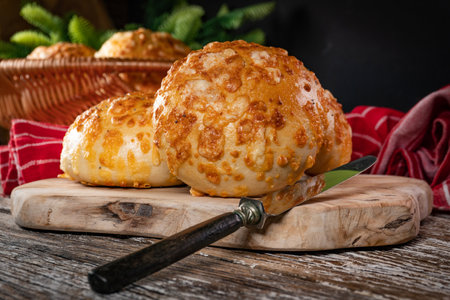Fresh breakfast rolls with cheese on cutting board.