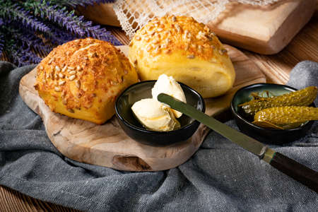 Tasty buns with cheese and sunflower seeds on wooden background.