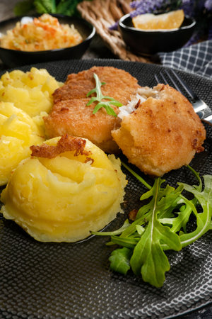 Fried cod fillet served with boiled potatoes and vegetable salad.の写真素材