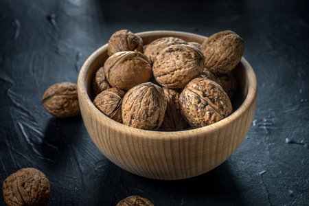 Walnuts in a wooden bowl on a dark background.の写真素材
