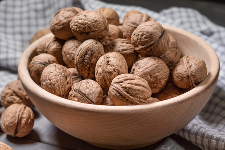 Whole walnuts in a wooden bowl. Shallow depth of field.