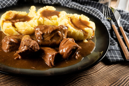 Stewed turkey meat served with sauce and mashed potatoes. Shallow depth of field.の写真素材