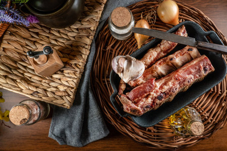 Smoked spare ribs with onion, garlic and spice in a cast iron roasting pan.の写真素材