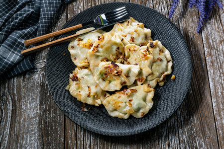 Fried dumplings (pierogi) with spinach filling sprinkled with greaves.