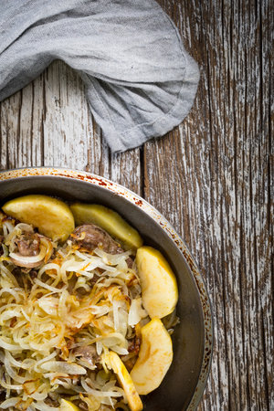 Roasted liver with apples and onions close-up in a pan on the table.の写真素材
