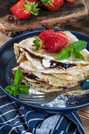 Polish pancakes with jam, cheese and strawberries.の写真素材