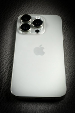KATOWICE, POLAND - DECEMBER 16, 2023 : Modern smartphone Apple iPhone 15 Pro and Apple Macbook Pro...