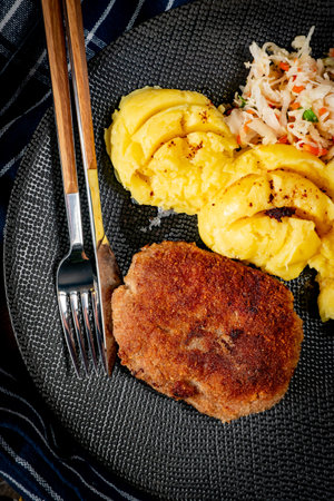 Homemade minced meat cutlet served with mashed potatoes and salad.