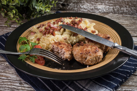 Minced meat cutlets with boiled sauerkraut on wooden table.