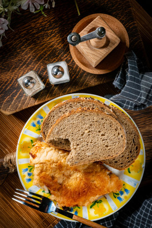 Fried cod fillet served with bread slices. Shallow depth of field.の写真素材