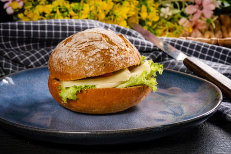 Roll with cheese and lettuce. Selective focus.