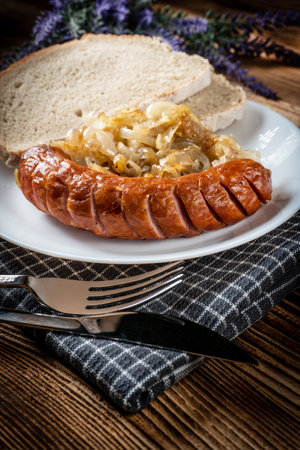 Pork sausage baked with onion on white plate. Shallow depth of field.の写真素材