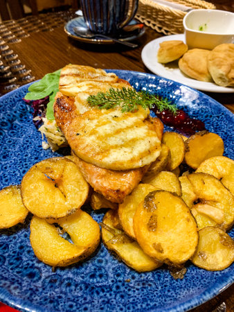 Fried chicken breast with fried cheese served with potato slices.の写真素材