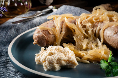 Fried white sausage with onions in a plate. Selective focus.の写真素材