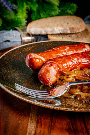 Fried sausage with onions in a plate. Shallow depth of field.の写真素材