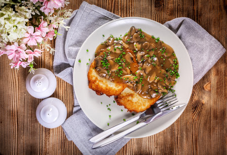 Crispy potato pancakes with mushroom sauce on wooden table.の写真素材
