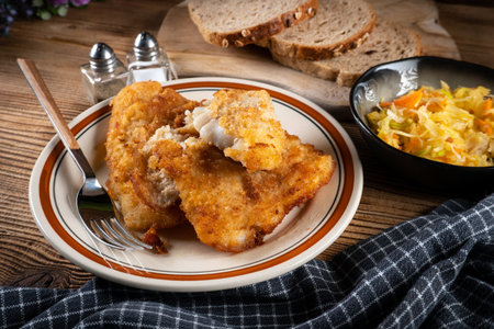 Fried cod fillet with sauerkraut and carrots. Shallow depth of field.の写真素材