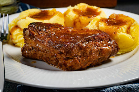 Braised pork ribs with spicy sauce served with mashed potatoes and salad. Shallow depth of field.