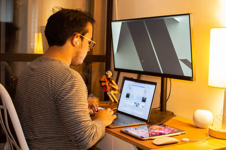 Programmer, web developer, designer working at office comparing mobile and desktop website versions Mexican latin holding phoneの写真素材