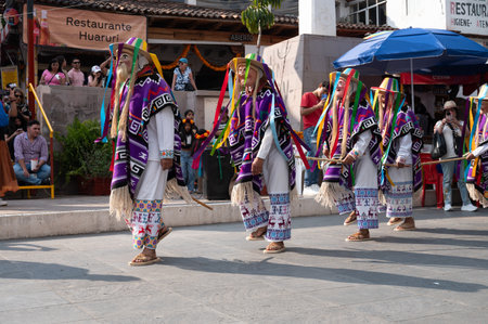 Group of dancers in vibrant costumes performing Danza de los Viejitos, a traditional folk dance from Michoacan, captured during Day of the Dead in Janitzio, Mexico.の写真素材