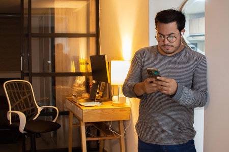 Happy Freelancer Receiving Good News on Phone at Home Officeの写真素材