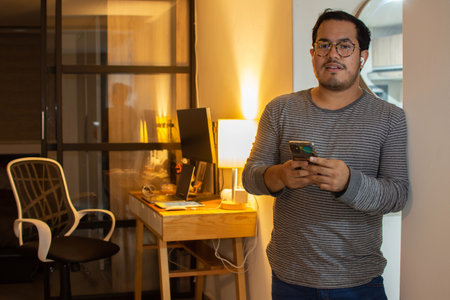 Happy Freelancer Receiving Good News on Phone at Home Officeの写真素材