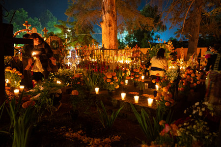 Candlelit graves decorated with marigold flowers on Day of the Dead nightの写真素材