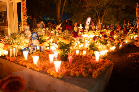 Candlelit graves decorated with marigold flowers on Day of the Dead nightの写真素材