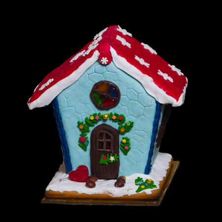 Small self-made gingerbread house isolated against black background close-up, selective focus, shallow DOF.の写真素材