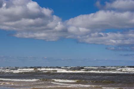 Landscape background with light clouds over Baltic sea near shoreline, selective focus.の写真素材