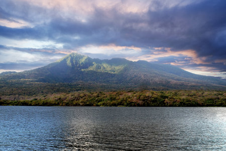 Mombacho Volcano Nature Reserve. The Mombacho volcano under a stormy sky, with a ray of sunlight on the volcano.Nicaraguaの写真素材