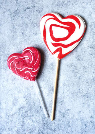 Top view of two heart-shaped lollypops on gray concrete background, Valentine's Day conceptの写真素材