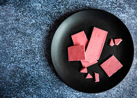 Pink or ruby chocolate, trendy modern dessert served on a black plate and dark gray background with copy spaceの写真素材
