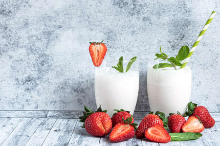 Milk shake in two glasses and fresh strawberriesの写真素材