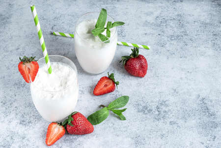 Milk shake in two glasses and fresh strawberriesの写真素材