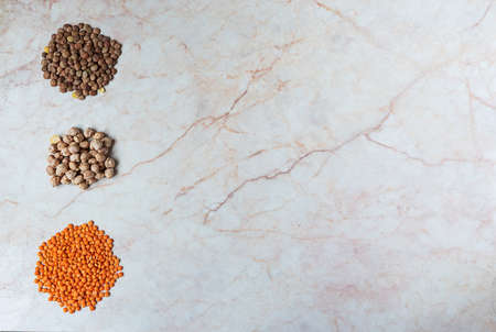 Chickpeas and two sorts of lentil on a marble backgroundの写真素材