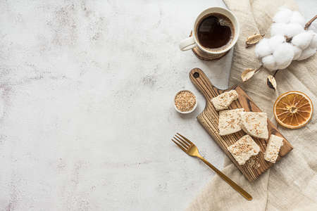 Sliced tahini halva on a wooden board, flat lay